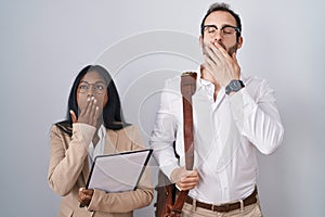 Interracial business couple wearing glasses bored yawning tired covering mouth with hand