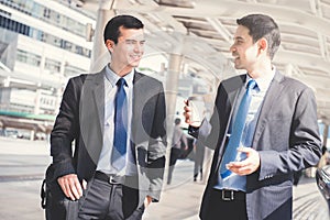 Interracial businessmen as colleague, walking and talking in the