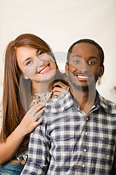 Interracial charming couple wearing casual clothes posing interacting friendly, white studio background