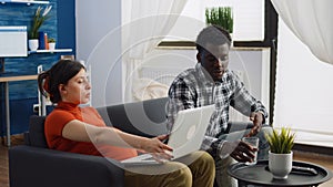 Interracial couple with pregnancy sitting together on couch