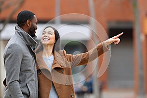 Interracial couple talking and pointing in the street