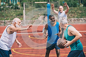 interracial elderly sportsmen playing basketball together