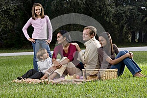 Interracial family of five having picnic in park