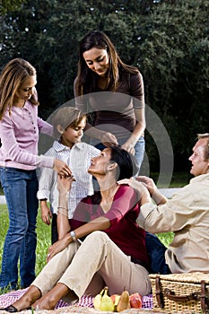 Interracial family of five having picnic in park