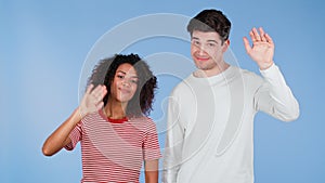 Interracial friendly couple - white man and african woman waving hands - goodbye, chao, adios. Parting, say bye to