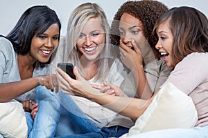 Interracial Group of Female Friends Laughing at Social Media on Smart Phone