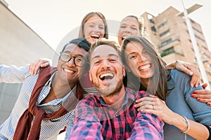 Interracial group of friends taking a selfie picture in the city