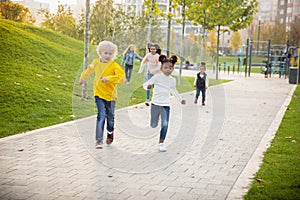 Interracial group of kids, girls and boys playing together at the park in summer day