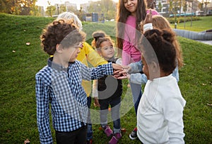 Interracial group of kids, girls and boys playing together at the park in summer day