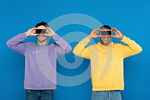 interracial hipsters covering eyes with blank