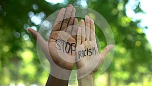 Interracial people hands with stop racism phrase, fight against discrimination