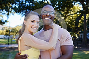 Interracial, portrait and couple hug, park or smile for relationship, romance or bonding. Love, black man or woman