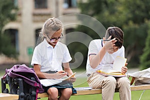 Interracial schoolkids looking at notebooks 