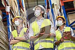 Interracial warehouse worker team with face mask