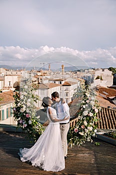 Interracial wedding couple. Destination fine-art wedding in Florence, Italy. A wedding ceremony on the roof of the