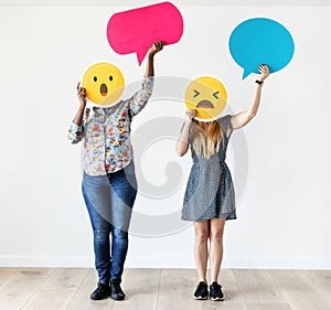 Interracial women holding an expressive emoticon face facial expression surprised and amazed social media and chat concept