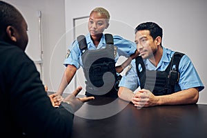 Interrogation, investigation and police team with a suspect for questions as law enforcement officers. Security, crime