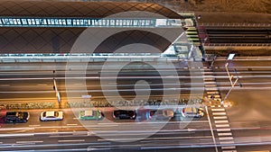 Intersection with cars and tram stop with railway aerial view from above night timelapse in Dubai Marina