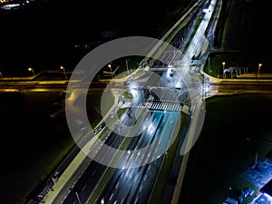 intersection at night from the drone wet road, road lighting wet road, road lighting cars road lanes