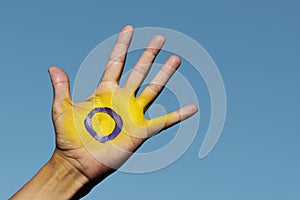 The intersex flag in the palm of the hand