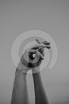 Intertwined hands of a man and a woman on a gray background,