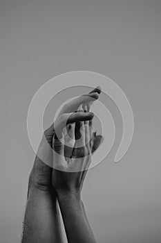 Intertwined hands of a man and a woman on a gray background,