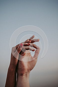 Intertwined hands of a man and a woman on a gray background,