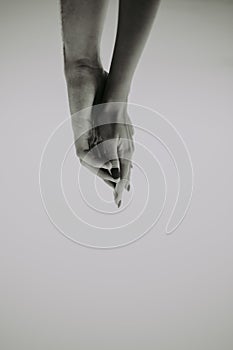 Intertwined hands of a man and a woman on a gray background,