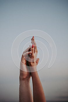 Intertwined hands of a man and a woman on a gray background,