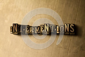 INTERVENTIONS - close-up of grungy vintage typeset word on metal backdrop photo