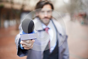 Interview, man and hand with microphone for press, news broadcast or question in the city. Tv journalist, conversation