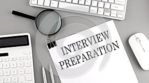 INTERVIEW PREPARATION written on paper with office tools and keyboard on the grey background