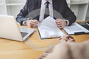 Interviewer or Board reading a resume during a job interview, Employer interviewing a young female job seeker for recruitment