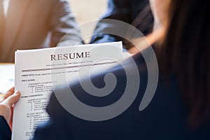 Interviewer reading a resume, Person submits job application, Person describe yourself to interviewer, Close up view of job photo
