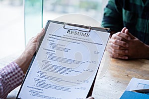 Interviewer reading a resume, Person submits job application, Person describe yourself to interviewer, Close up view of job