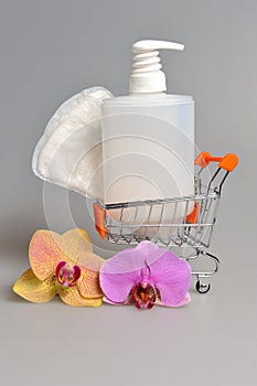 Intimate gel dispenser pump plastic bottle, sanitary towel in pushcart with orchid flowers