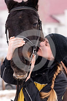 Intimate moment between person and horse in the snow