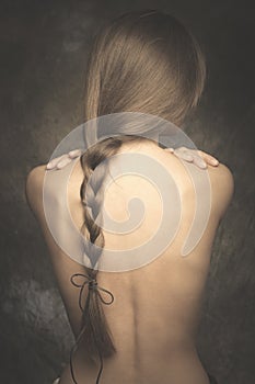 Intimate woman portrait bare back and long braid