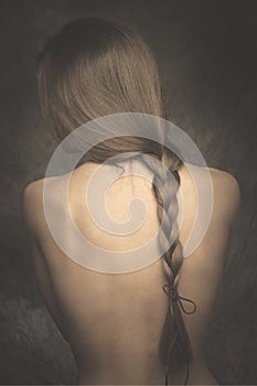 Intimate woman portrait bare back and long braid