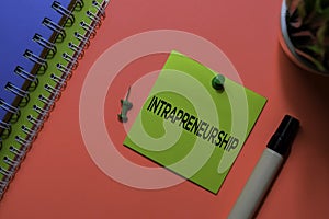 Intrapreneurship write on sticky notes. Isolated on pink table background photo