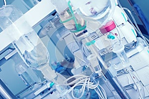 Intravenous drip with saline bottles on the background of digital equipment