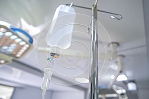 Intravenous or Iv fluids drip bottle hanging on a metal pole in hospital emergency room