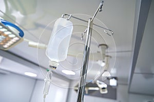 Intravenous or Iv fluids drip bottle hanging on a metal pole in hospital emergency room
