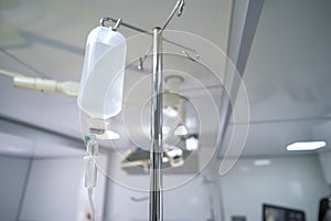 Intravenous or Iv fluids drip bottle hanging on a metal pole in hospital emergency room