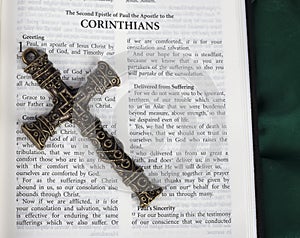 Intricate antique cross with Corinthians verse in Holy Bible