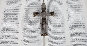 Intricate antique cross on open Holy Bible