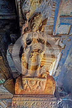 Intricate carving of an amorous couple on bracket figure in cave