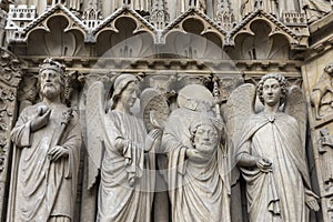 Intricate carvings of Catholic saints on the exterior walls of Notre Dame Cathedral, Paris, France.