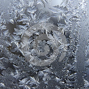 Intricate frost patterns on glass create beautiful, leaf-like structures. The ice crystals