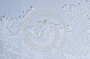 Intricate ice crystals form a delicate, mesmerizing pattern on a cold winter window surface.